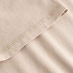 Close-up of beige fabric with a focus on texture and stitching.