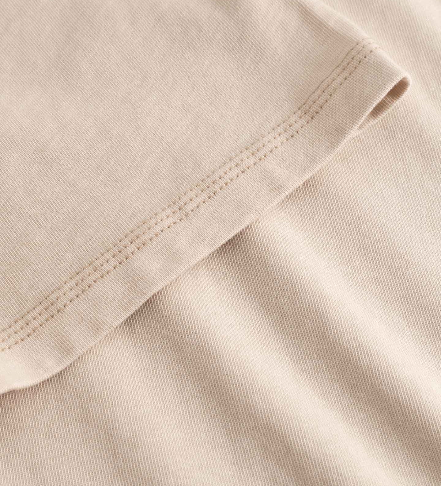 Close-up of beige fabric with a focus on texture and stitching.