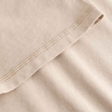 Close-up of beige fabric with a focus on texture and stitching.