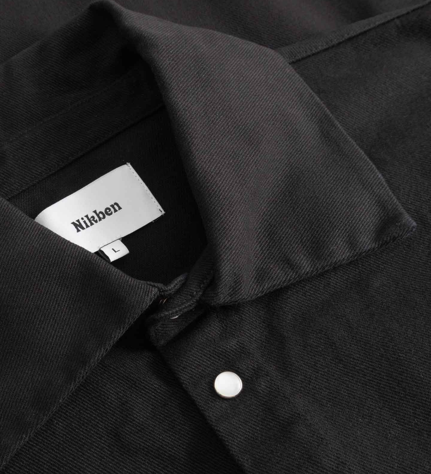 Close-up of black overshirt with Nikken label inside the collar