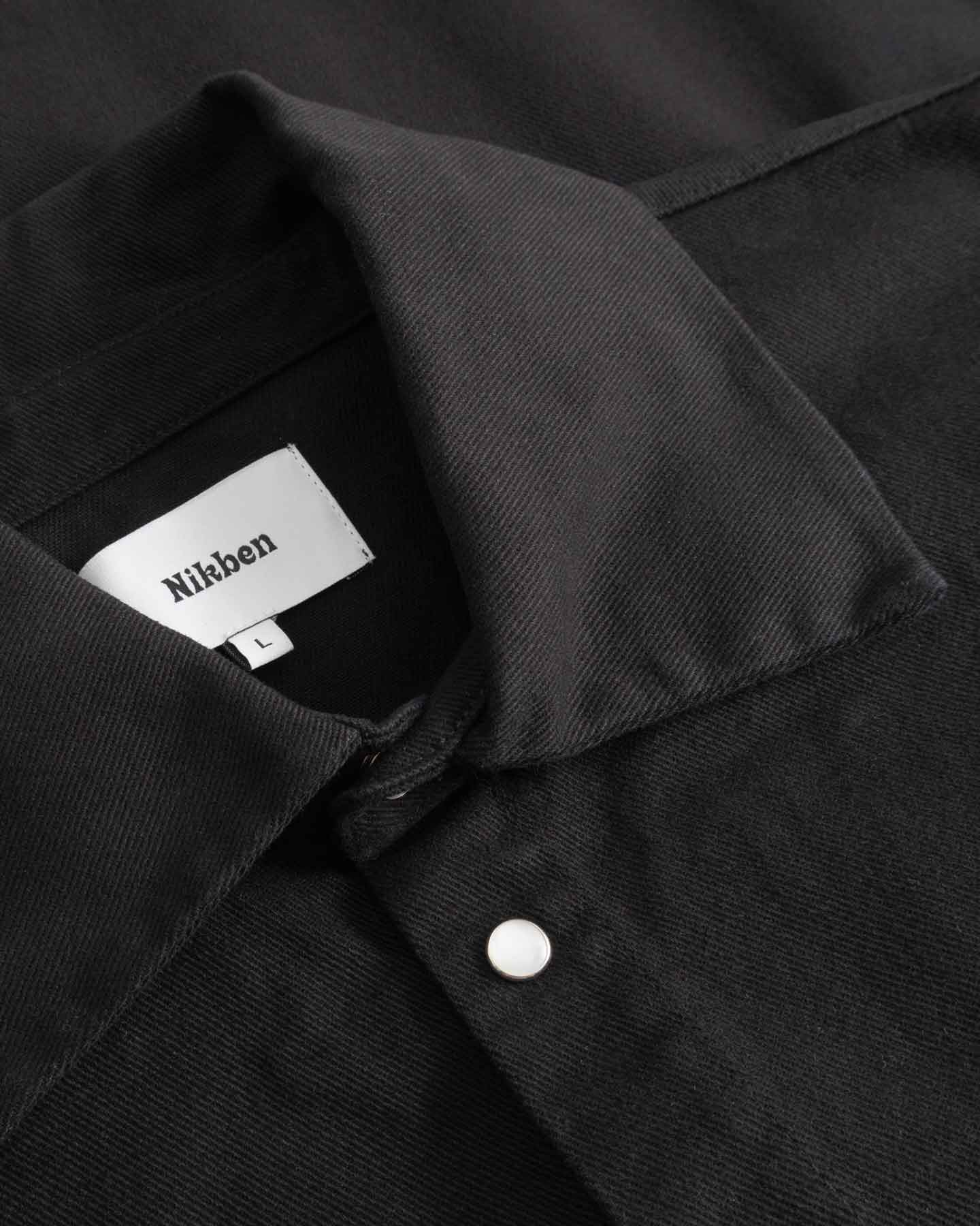Close-up of black overshirt with Nikken label inside the collar