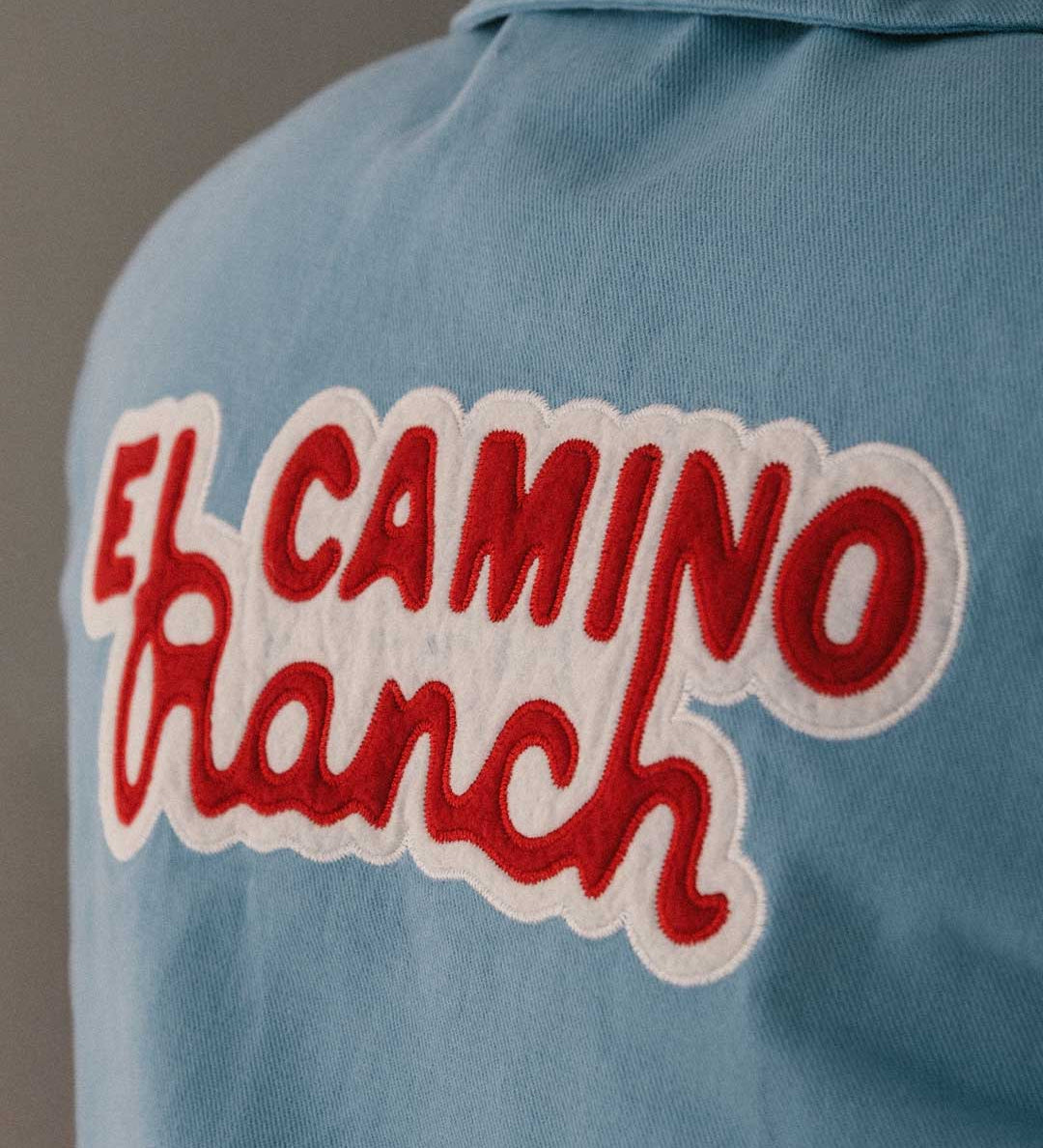 Blue overshirt with 'El Camino Ranch' text in red and white on the back 