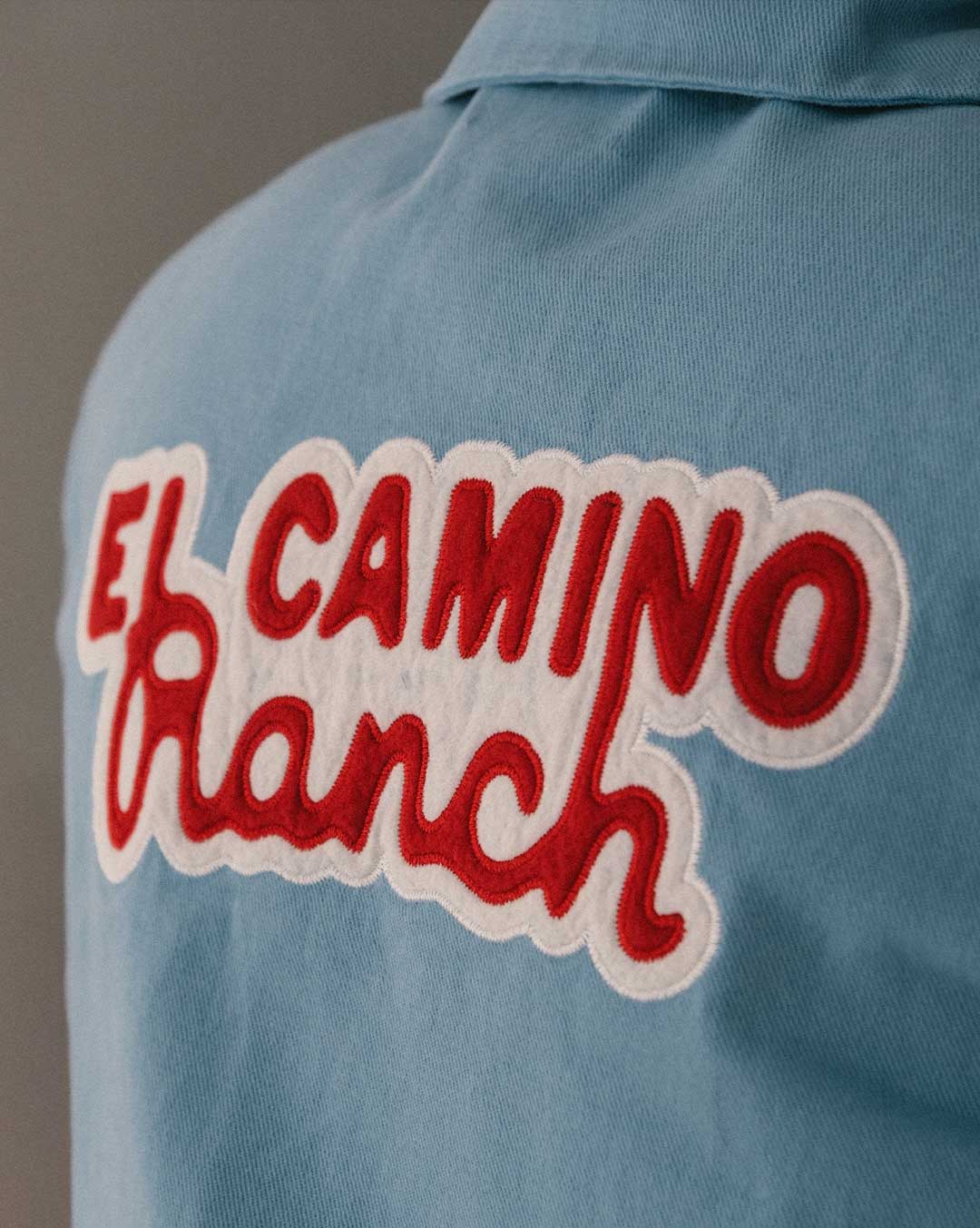 Blue overshirt with 'El Camino Ranch' text in red and white on the back 