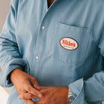 model wearing  blue overshirt with a 'Nikben' logo on breast pocket