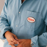 model wearing  blue overshirt with a 'Nikben' logo on breast pocket