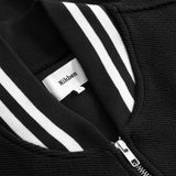 Close-up of black bomber jacket with white stripes and a visible brand label.