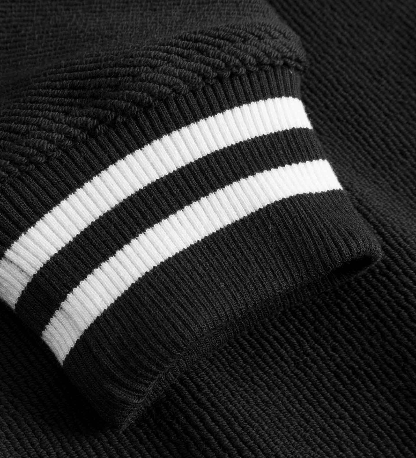 Close-up of sleeve with white stripes on black bomber jacket