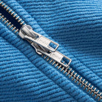 Close-up of a silver double zipper on blue fabric