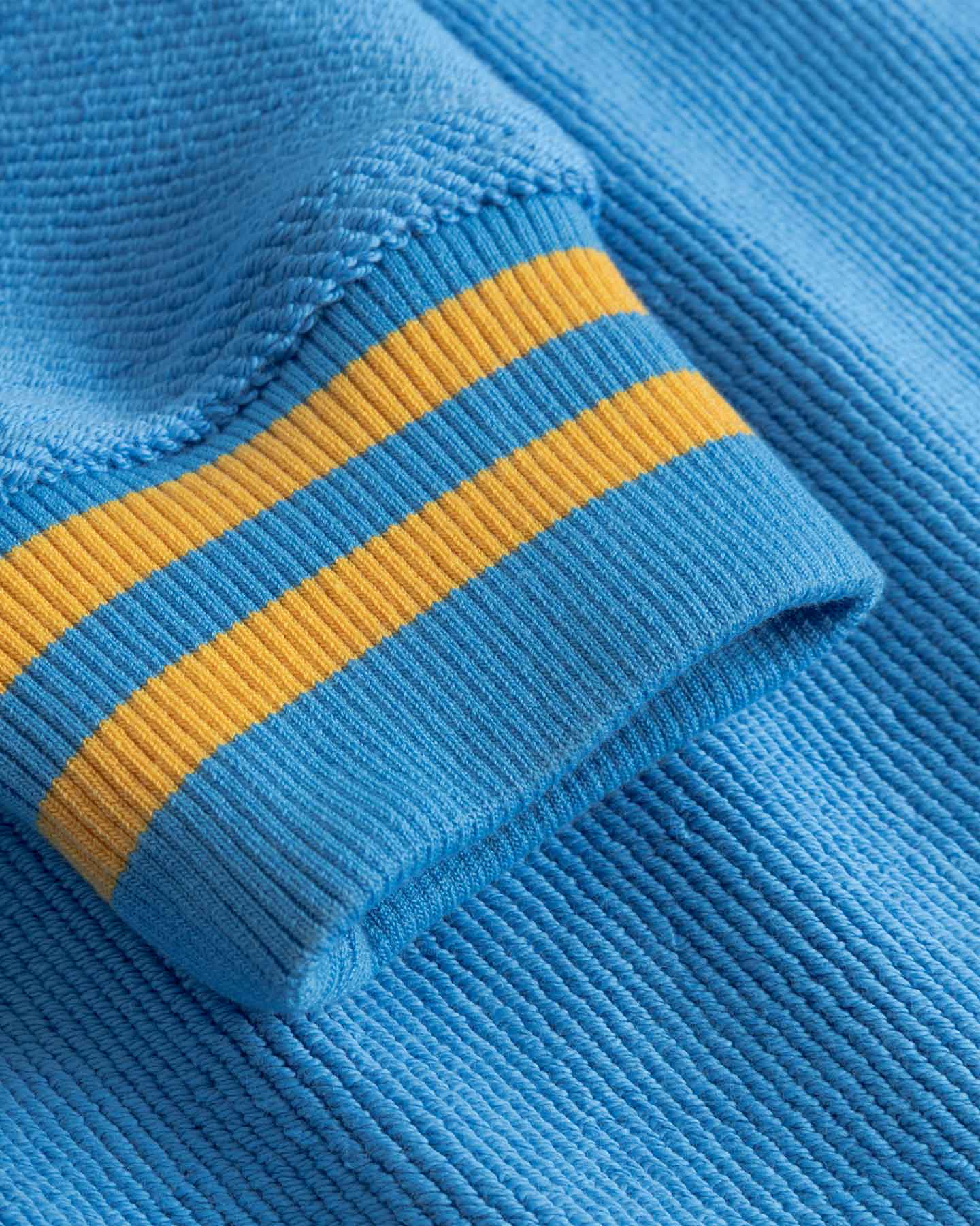 Close-up of blue fabric with yellow stripes on sleeve