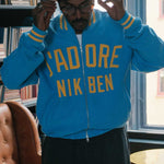 Model wearing Blue bomber jacket with yellow text on front