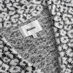  Label displaying the brand 'Nikben'. on a black white cardigan