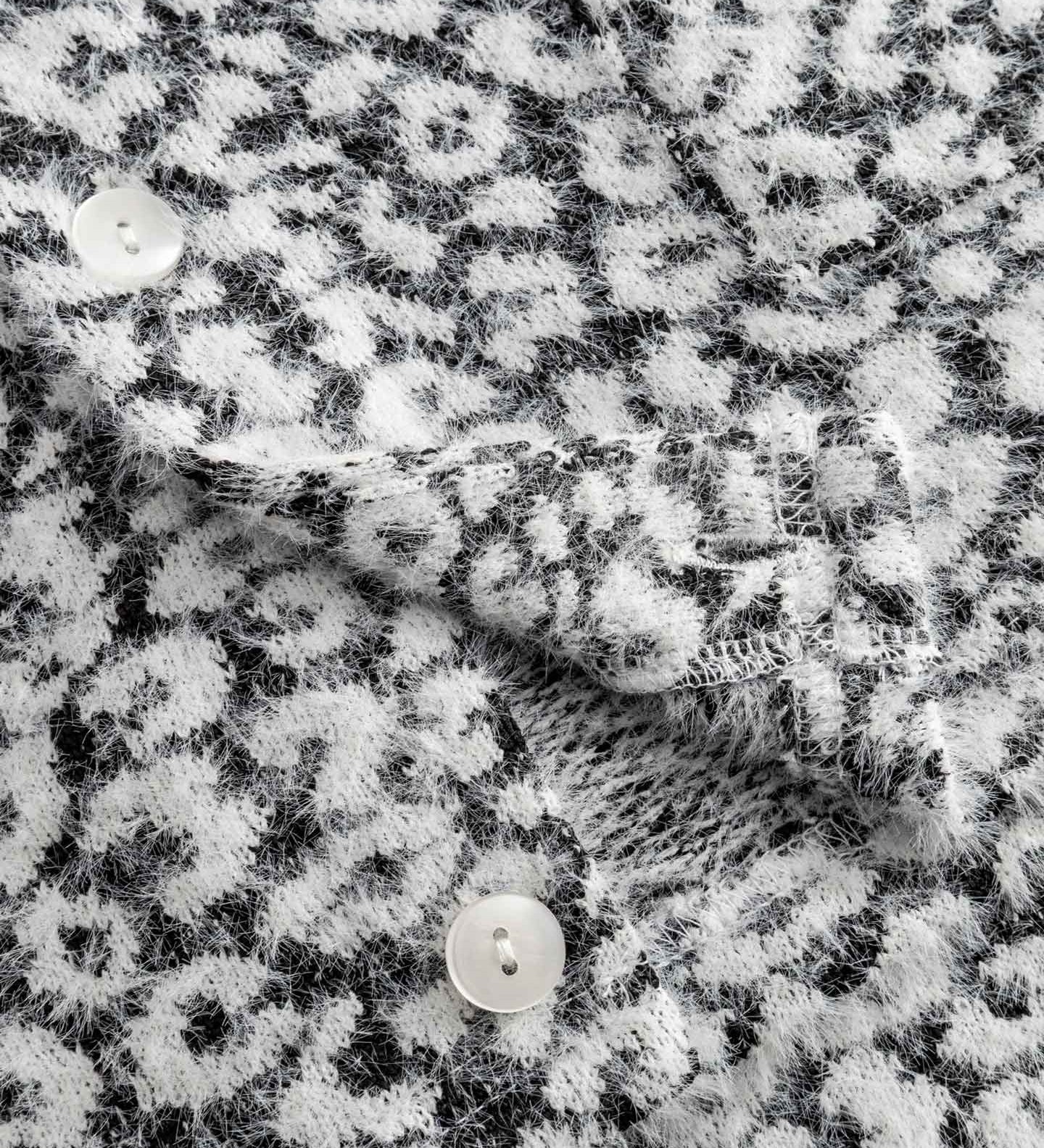 Close-up of textured black and white fabric on cardigan