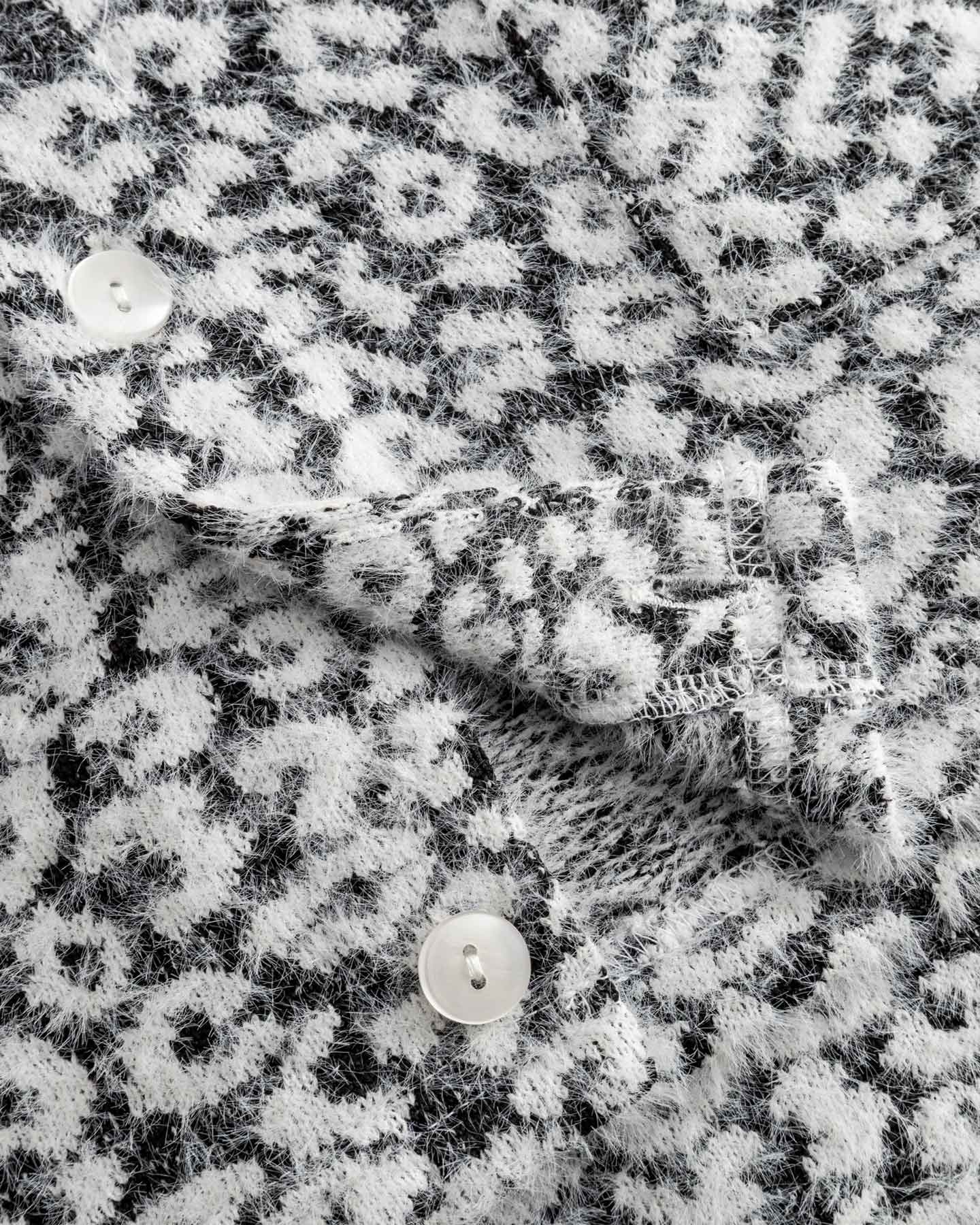 Close-up of textured black and white fabric on cardigan