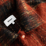 Close-up detail of a red and black checkered fabric with  Nikben label.