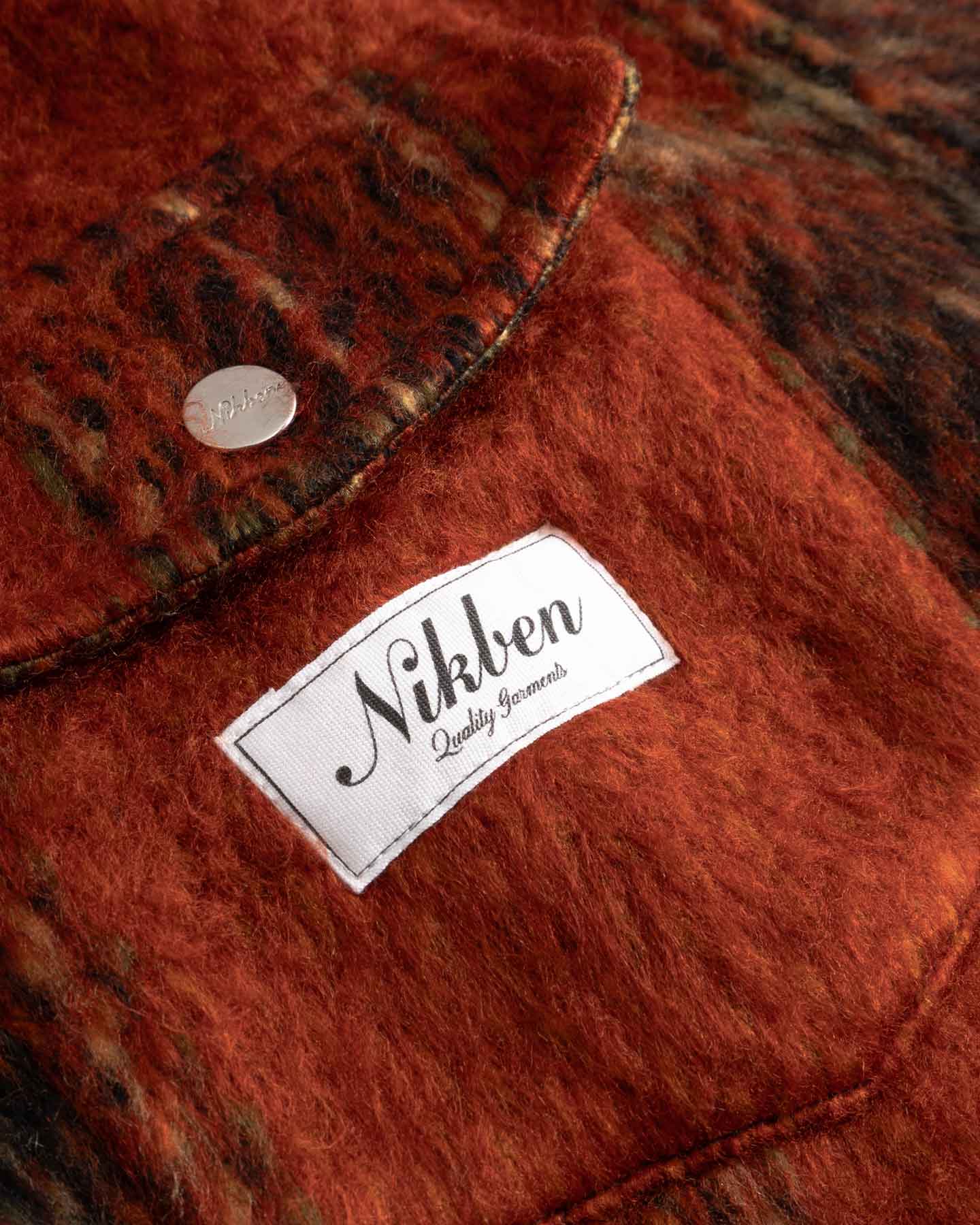 Close-up of front breast button down pockets fabric with a Nikben label