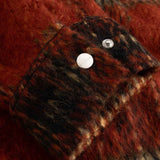 Close-up of red and black textured fabric on sleeve cuff with silver button detail