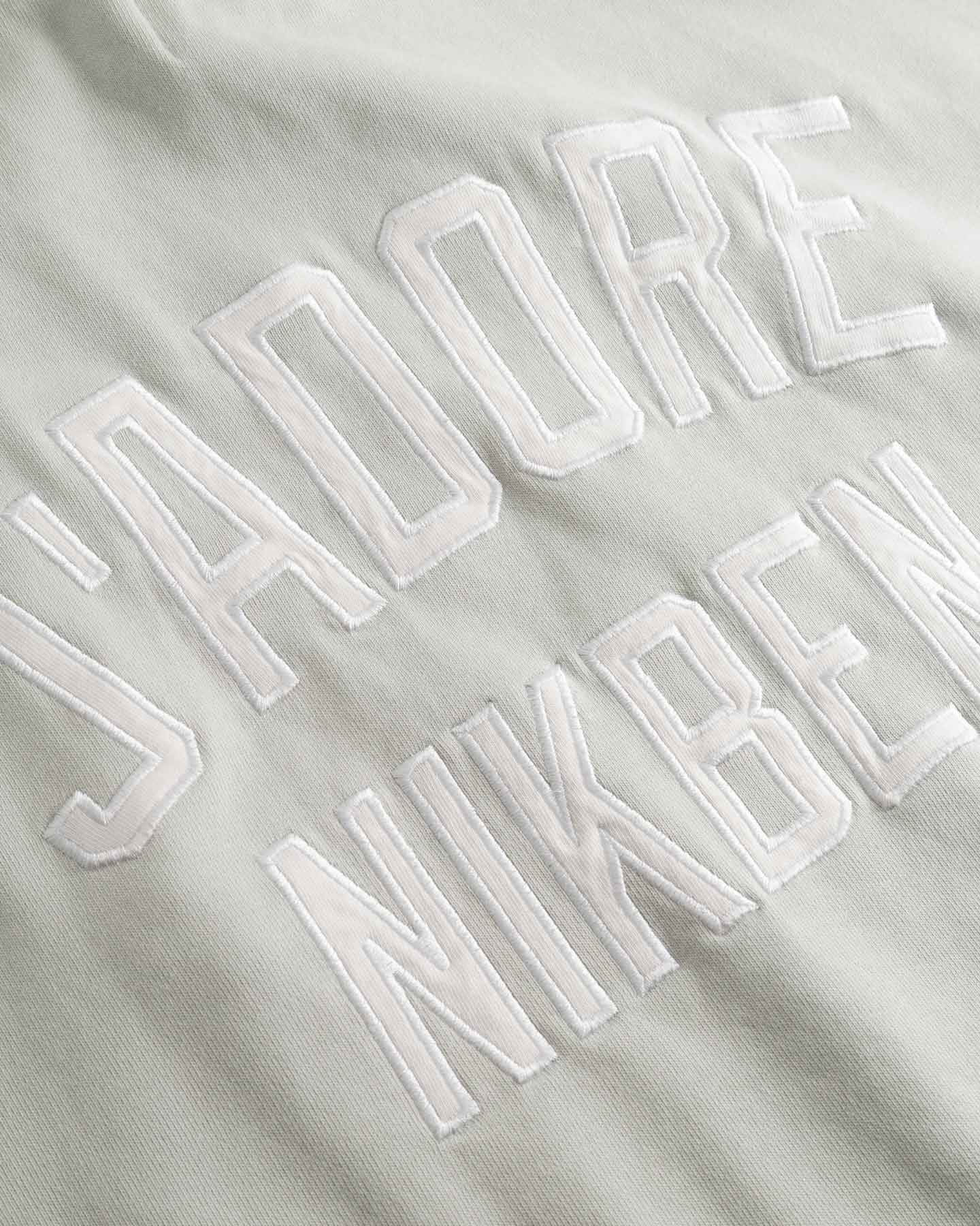 Close up of Embroidered text on a beige fabric background