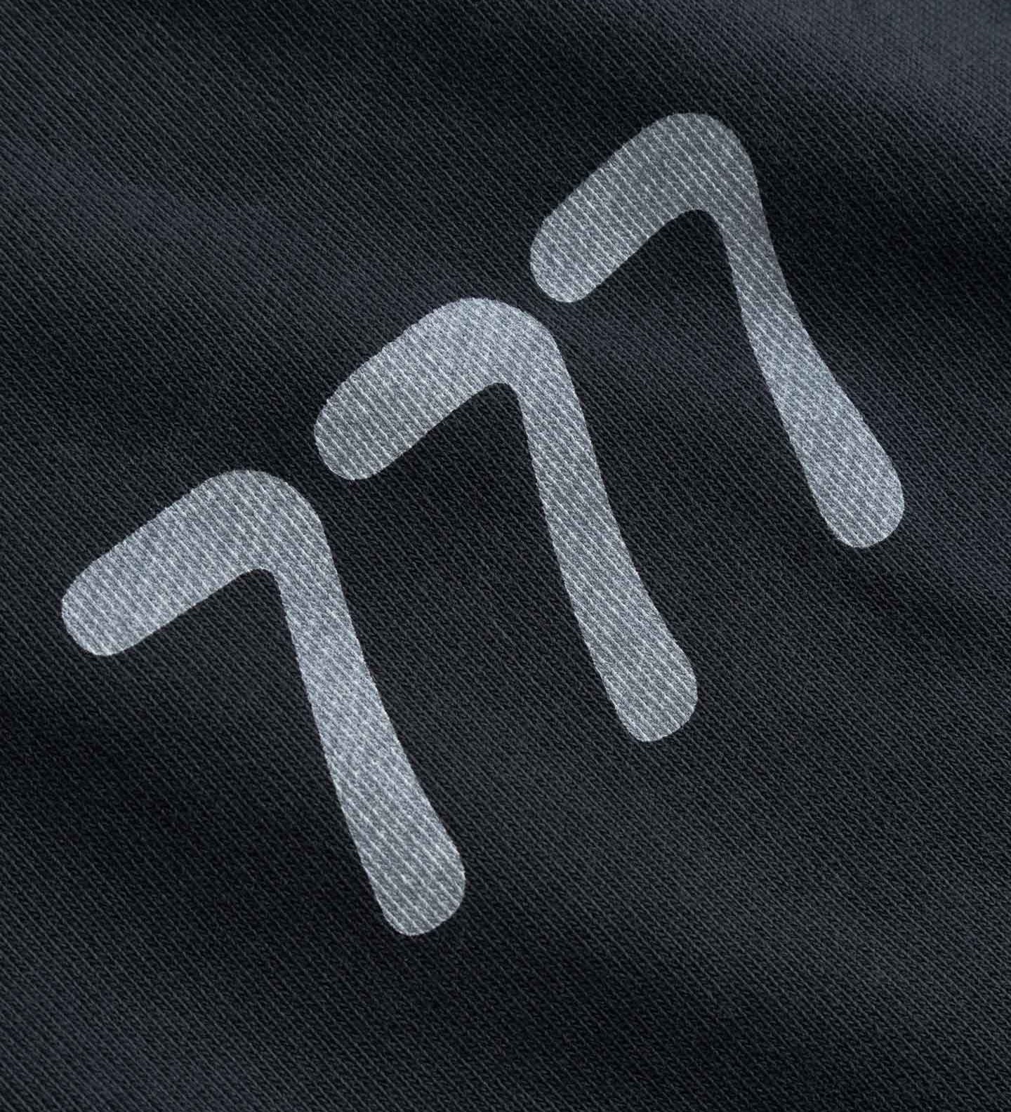 Close-up of a black fabric with white 777 logo