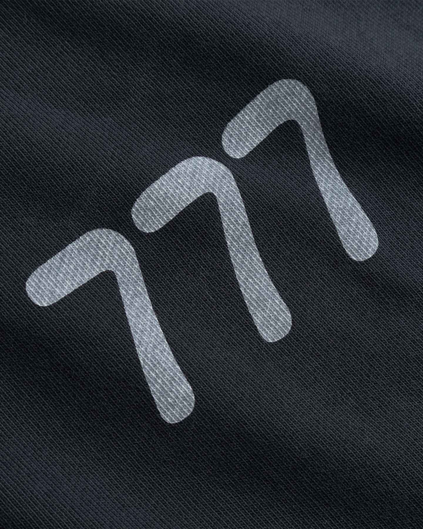 Close-up of a black fabric with white 777 logo