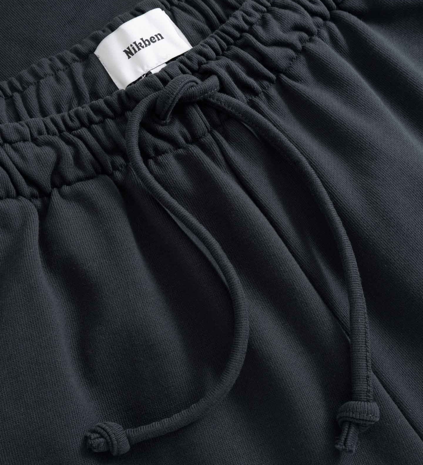 Black pants with a drawstring and visible brand label 