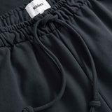 Black pants with a drawstring and visible brand label 