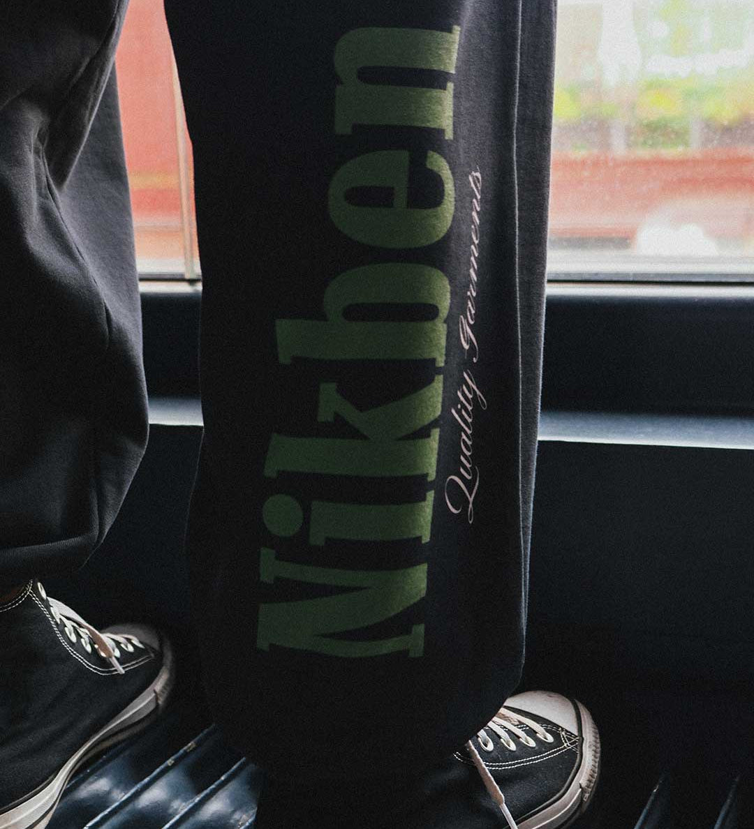 black pants with bold green logo on leg