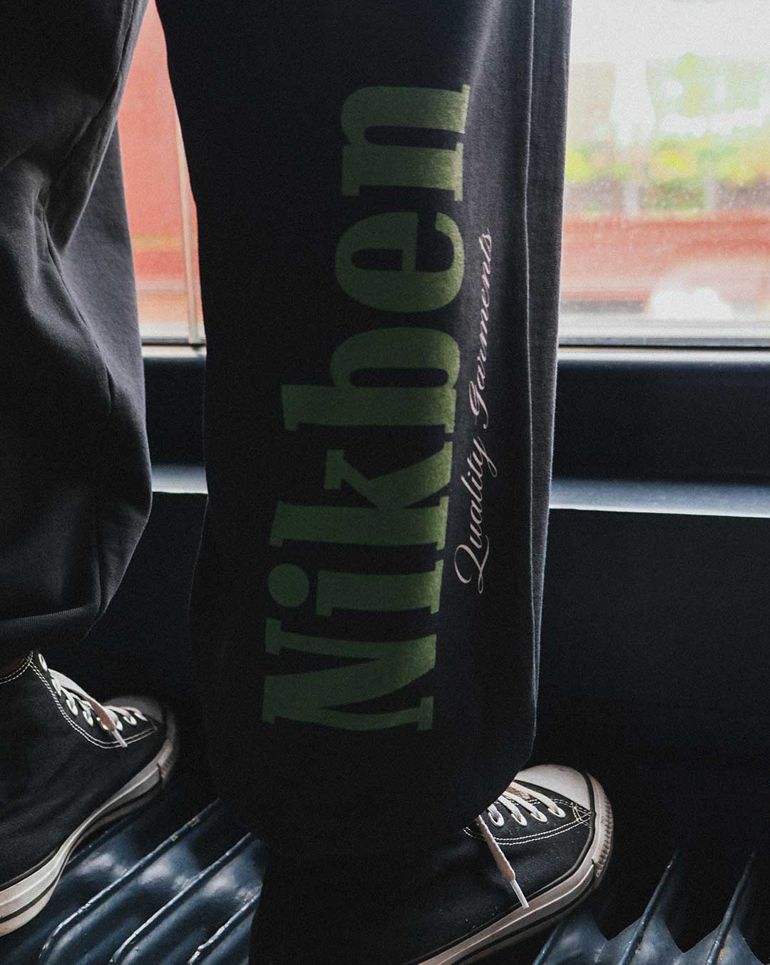 black pants with bold green logo on leg
