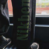 black pants with bold green logo on leg
