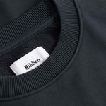Black sweater with a visible brand label on the collar