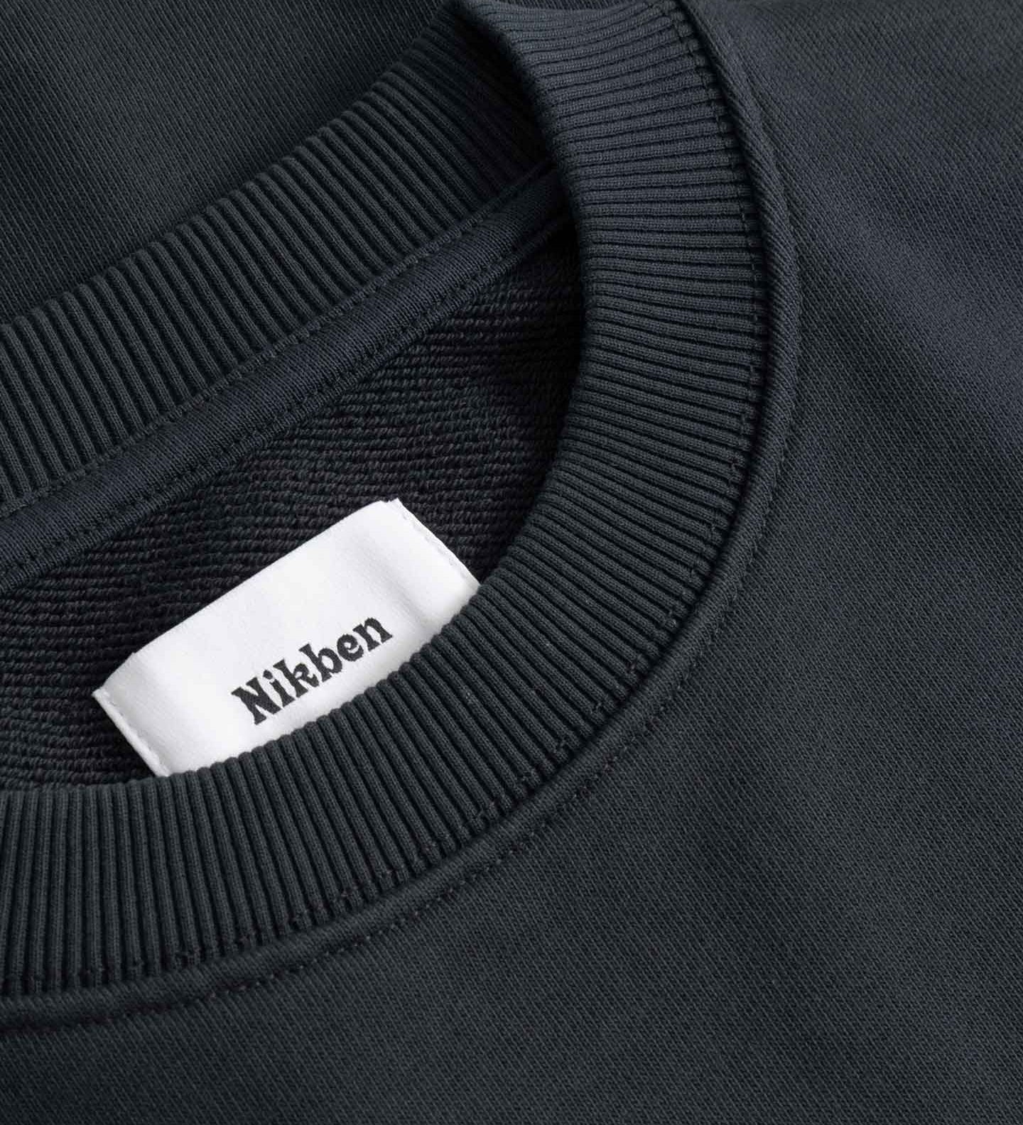 Black sweater with a visible brand label on the collar