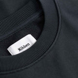 Black sweater with a visible brand label on the collar