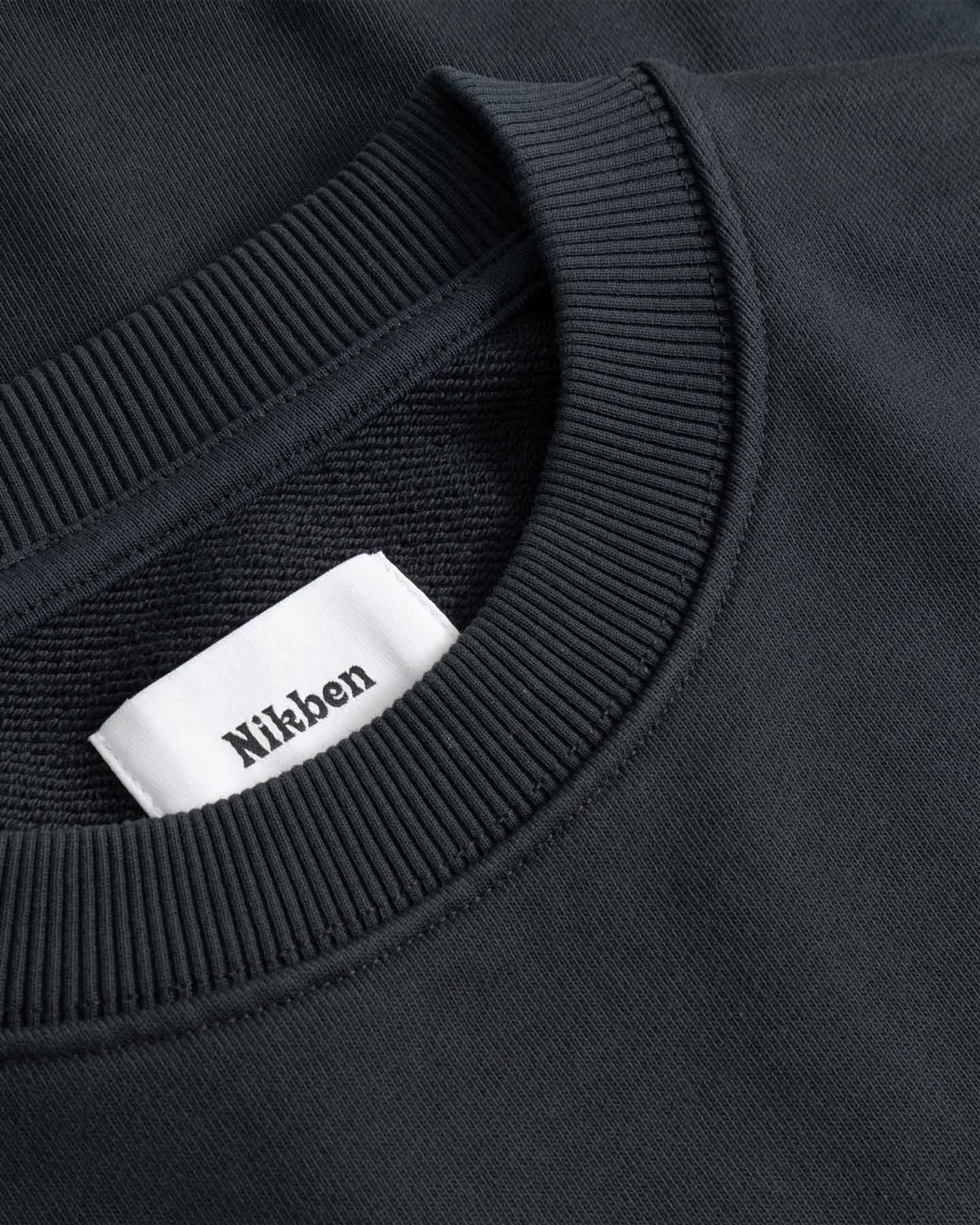 Black sweater with a visible brand label on the collar