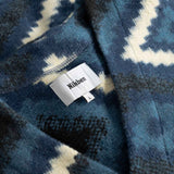 Close up of blue and white diamond Ikat patterned fabric with visible brand label