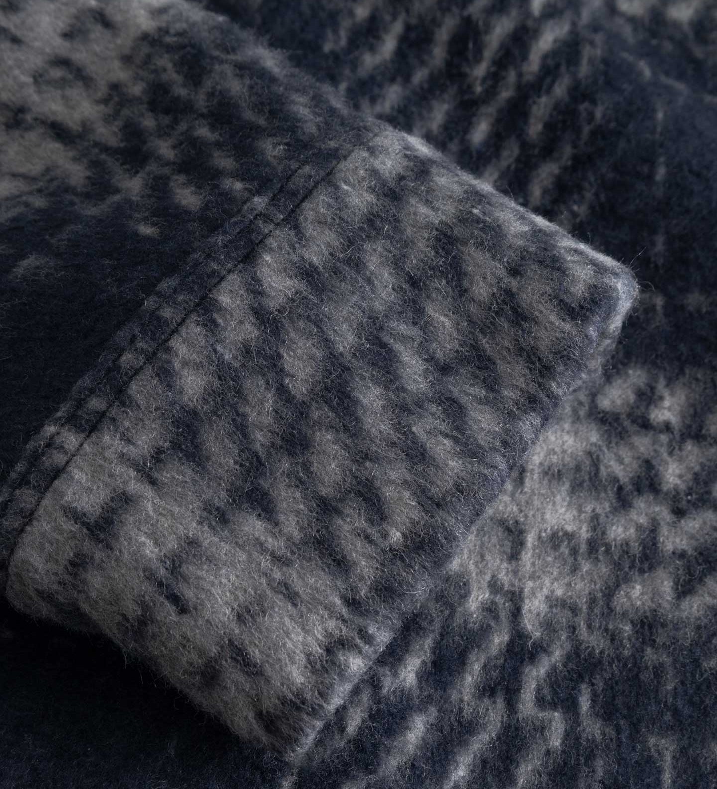 Close up of sleeve of a navy grey overshirt 