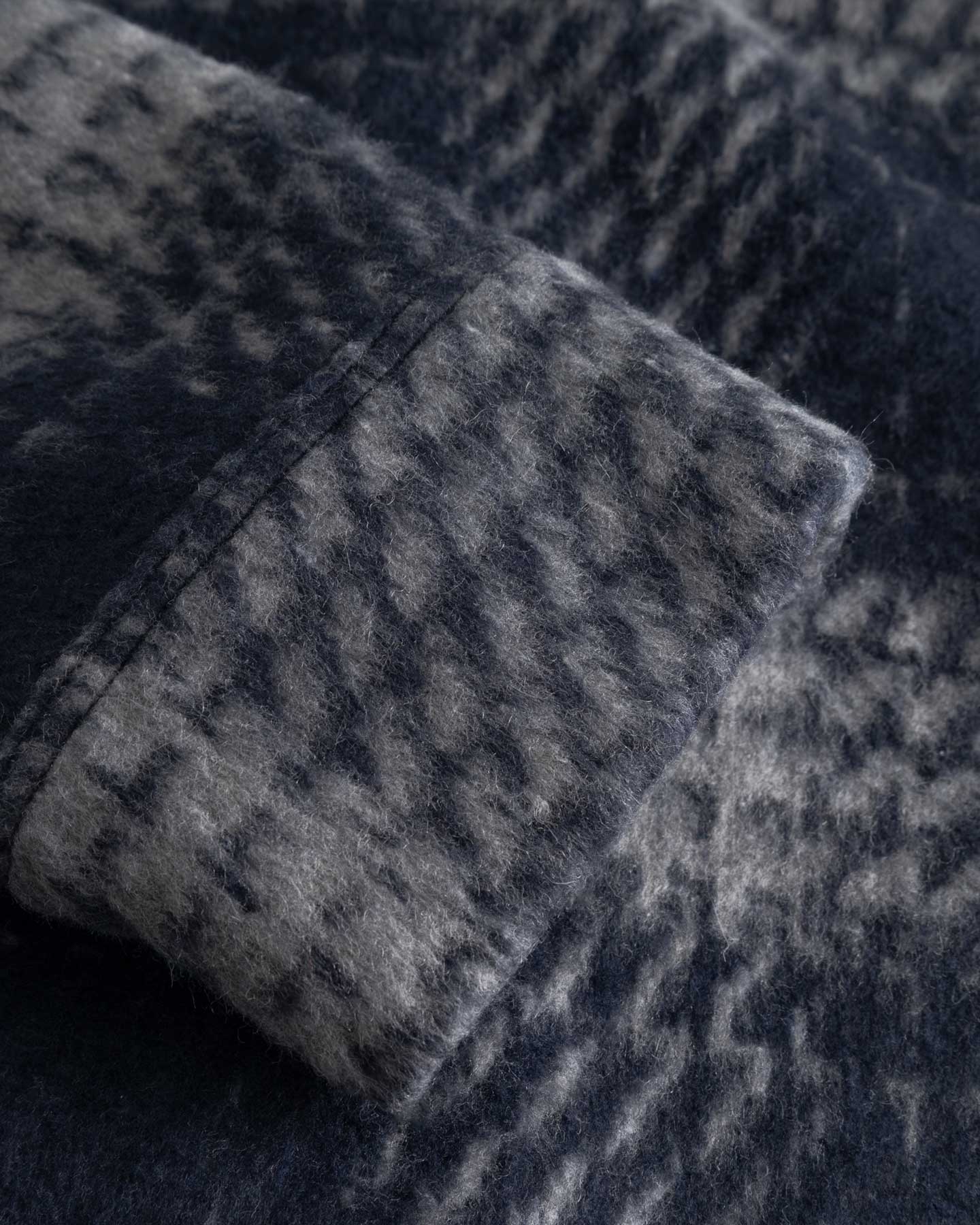 Close up of sleeve of a navy grey overshirt 