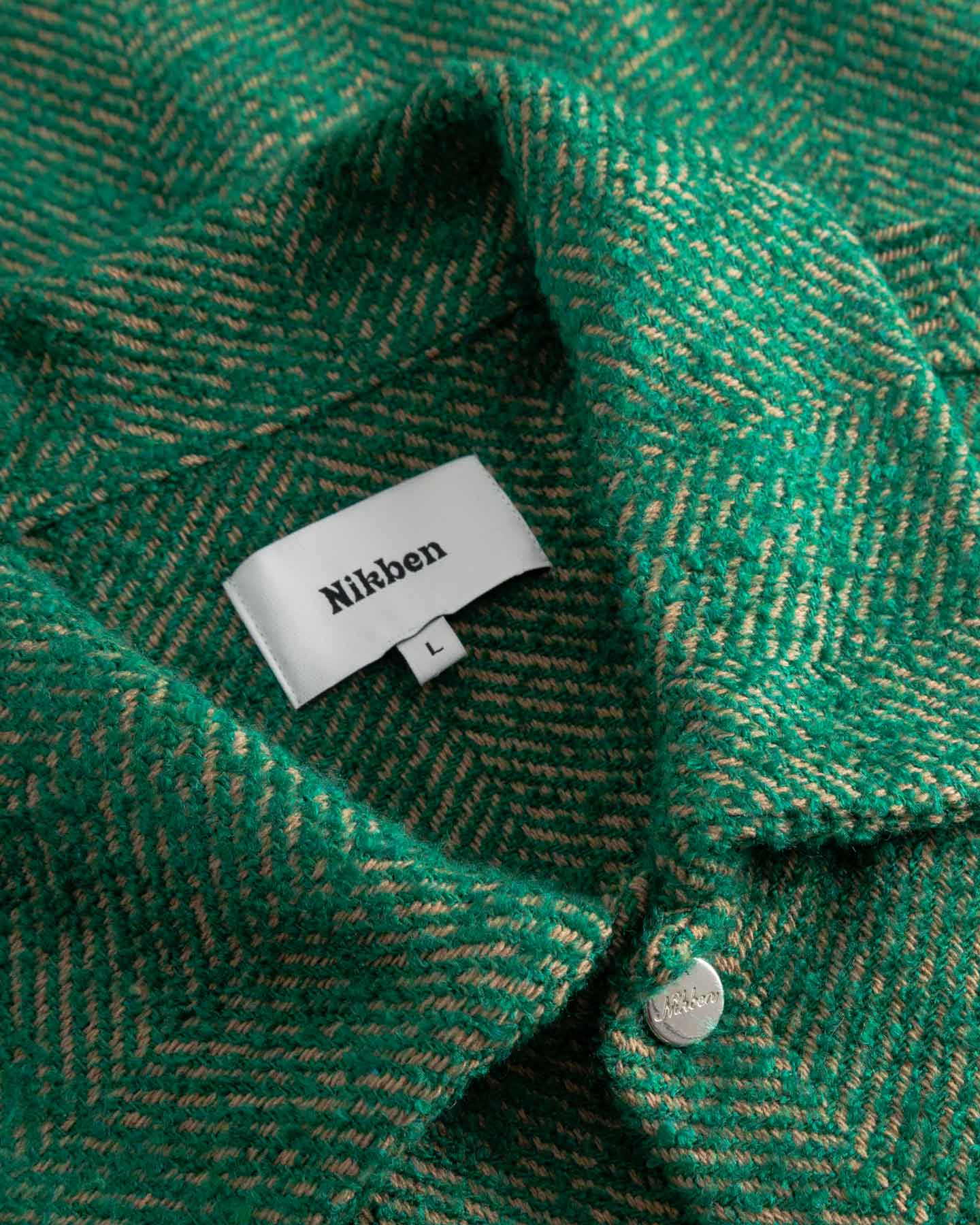 Close-up of a green textured fabric with a Nikben label.