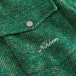 Close-up of a green textured fabric with 'Nikben' branding in white.