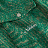 Close-up of a green textured fabric with 'Nikben' branding in white.
