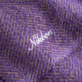 Close up of Purple fabric with 'Nikben' logo in white