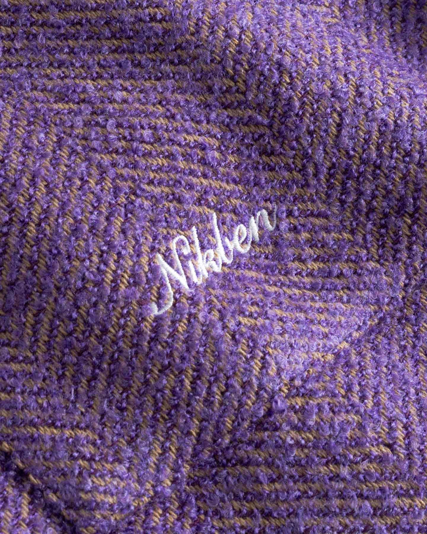 Close up of Purple fabric with 'Nikben' logo in white