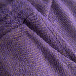 Close-up of textured purple fabric with a herringbone pattern