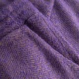 Close-up of textured purple fabric with a herringbone pattern