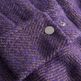Close-up of  purple textured fabric cuff with a button down button