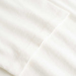 Closeup view of arm stitchings on white T-shirt