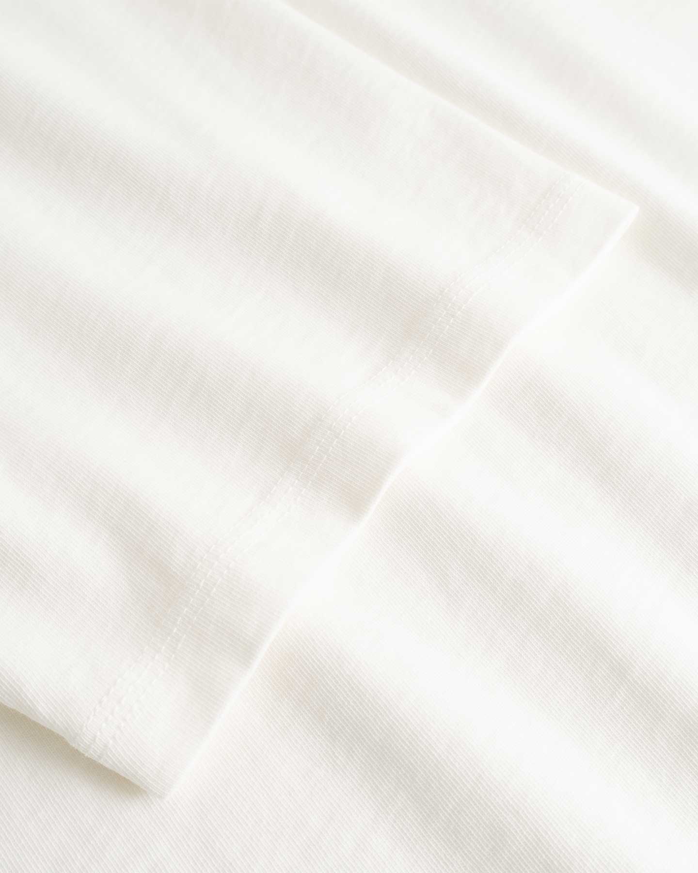 Closeup view of arm stitchings on white T-shirt