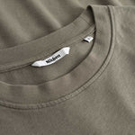 Closeup view of Nikben necklabel on green T-shirt
