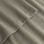 Closeup view of arm stitchings on green T-shirt