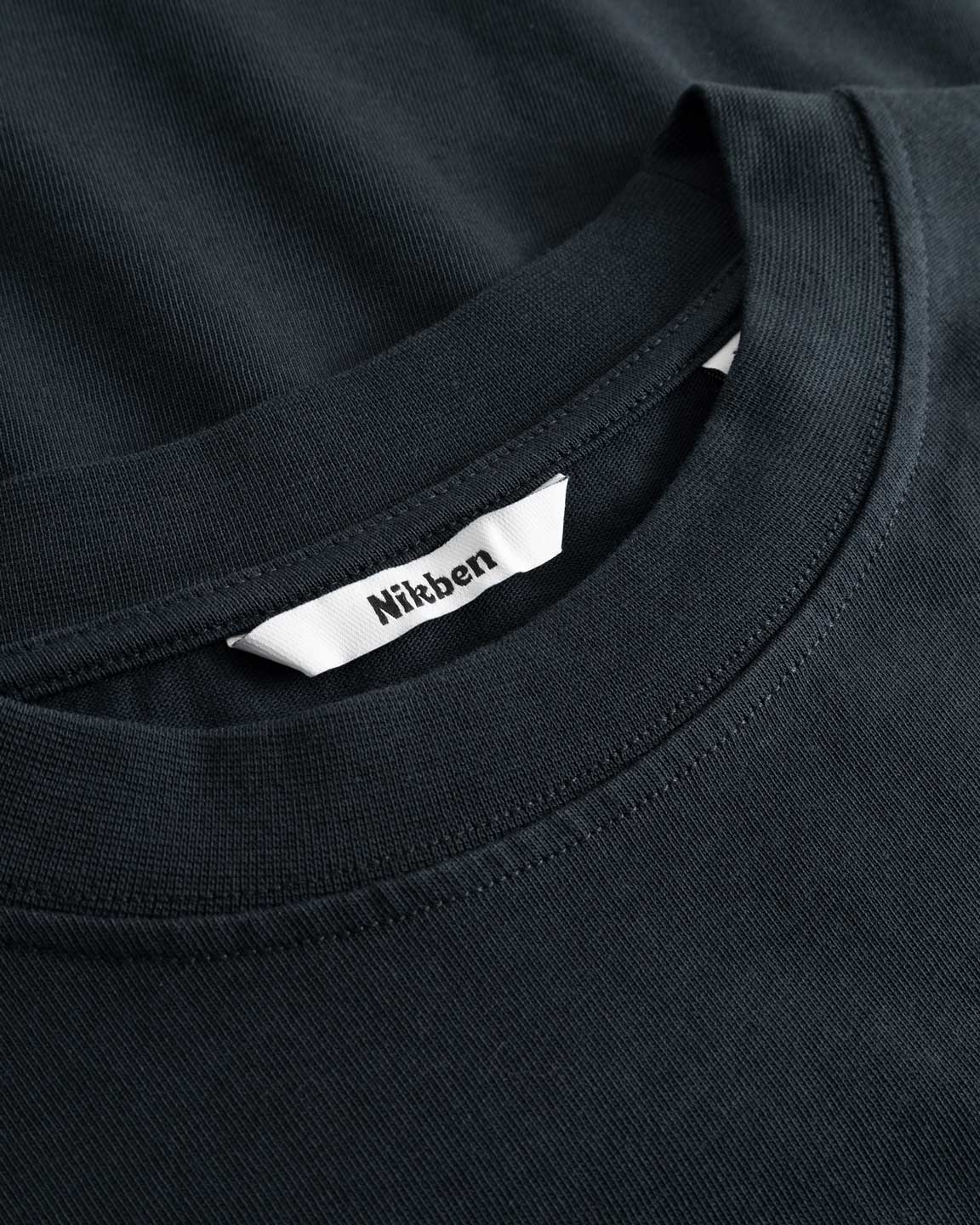 Closeup view of Nikben necklabel on black T-shirt