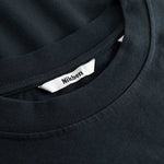 Closeup view of Nikben necklabel on black T-shirt