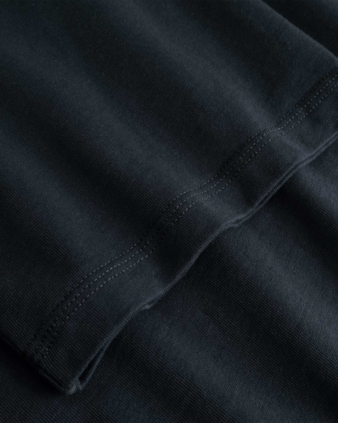 Closeup view of arm stitchings on black T-shirt
